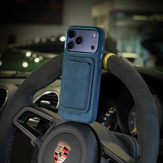 Alcantara iPhone case with MagSafe wallet in Midnight Blue on car steering wheel interior
